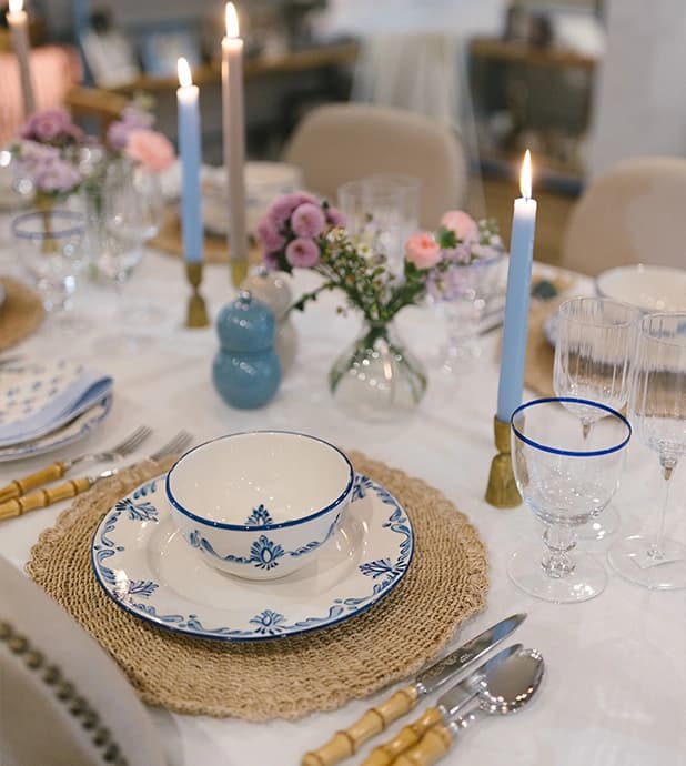 A beautiful pastel blue and pink tablescape design with handpainted tableware, brass homeware accessories and spring flowers