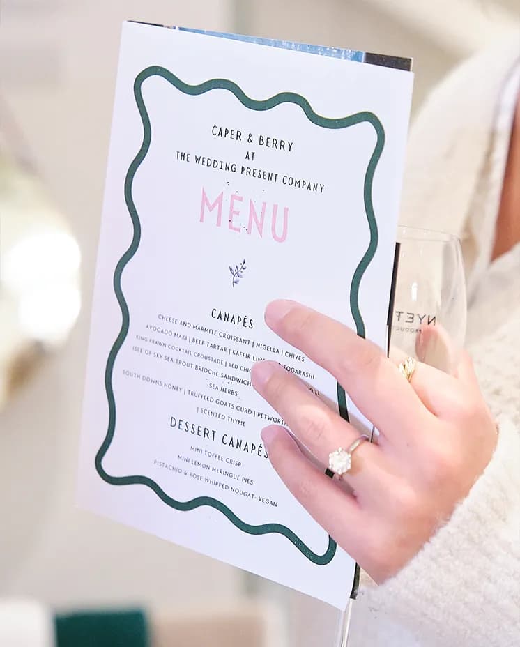 Bride-to-be holds a wedding catering menu at The Wedding Present Company showcase