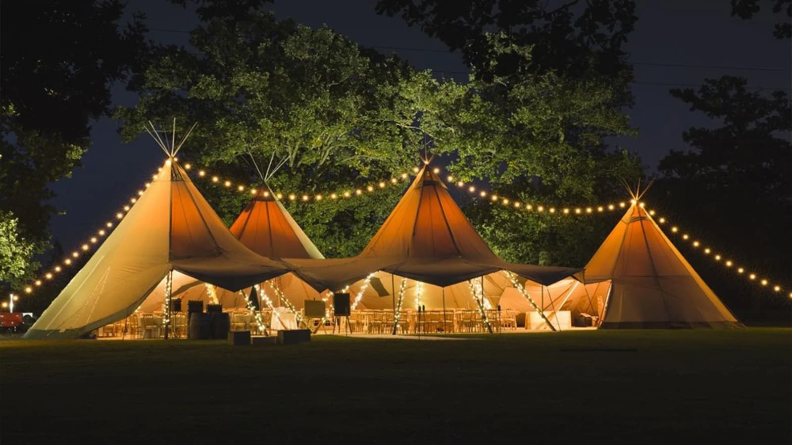 Wedding tipi with festoon lights at night