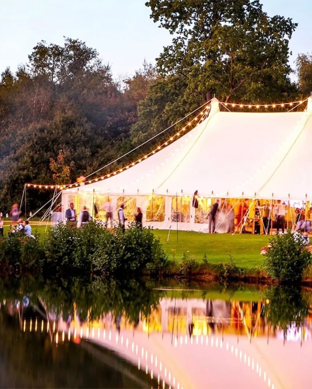 Traditional pole marquee wedding next to a lake