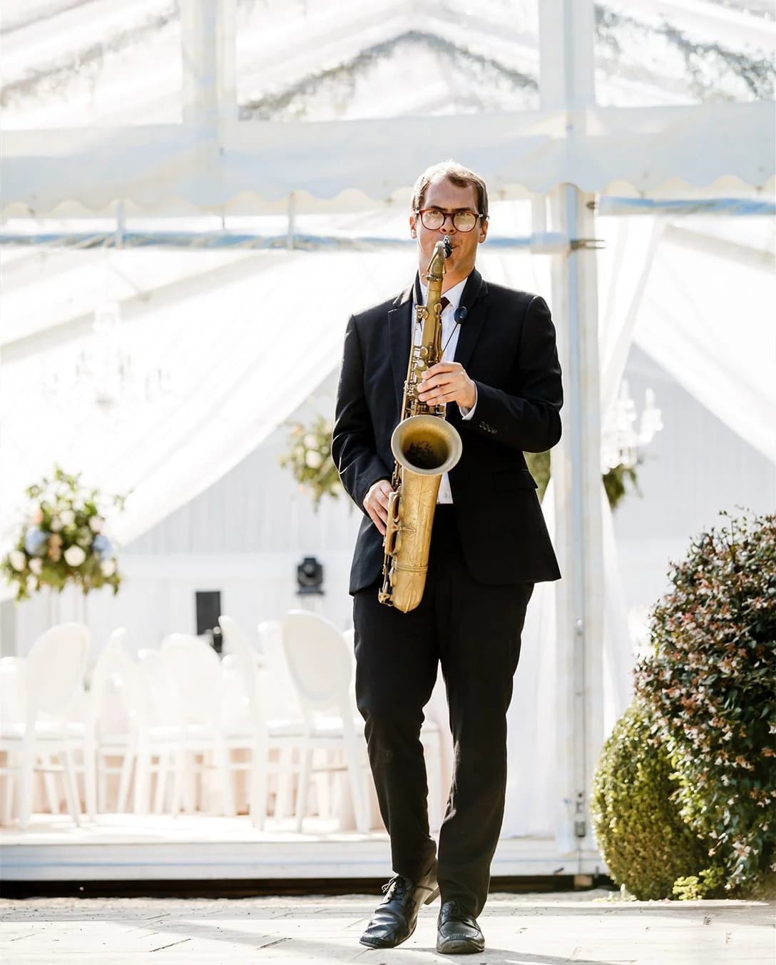 A saxophonist outside the clearspan wedding marquee