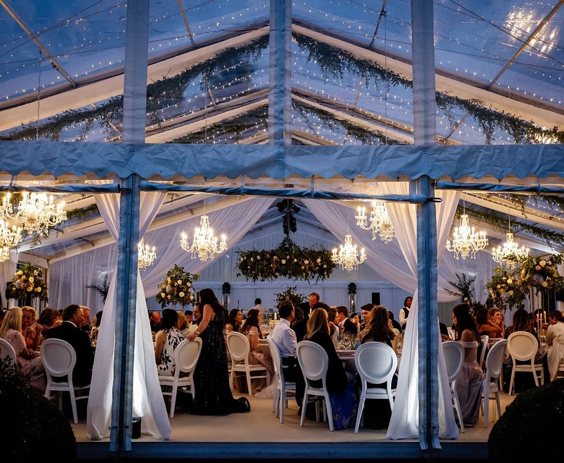Wedding guests enjoying celebrations inside clearspan framed marquee