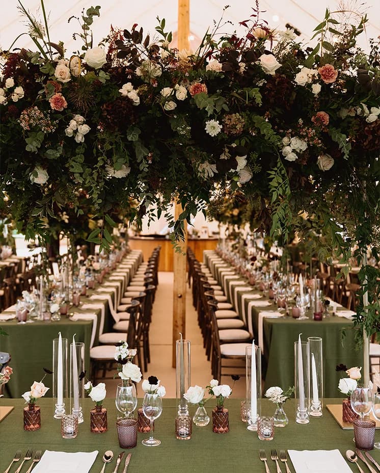 Dark green wedding table décor with statement floral arrangement