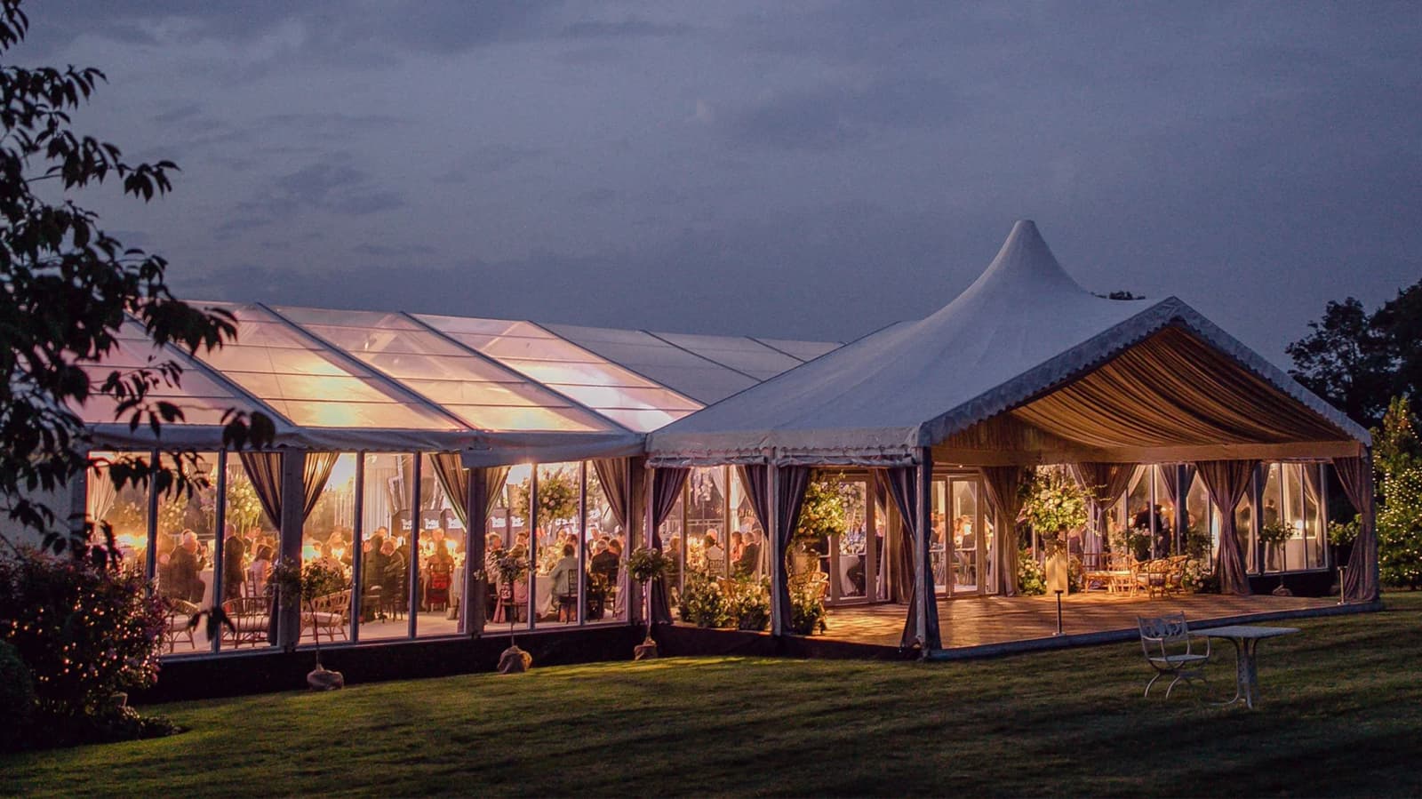Clearspan framed wedding marquee with drapes in the evening