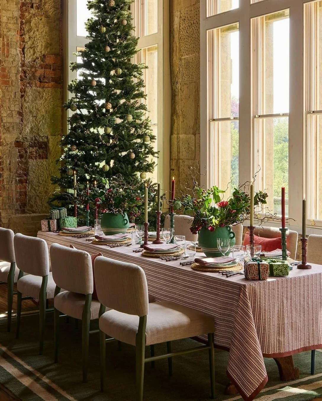 A festive table setting with a Christmas tree in the corner