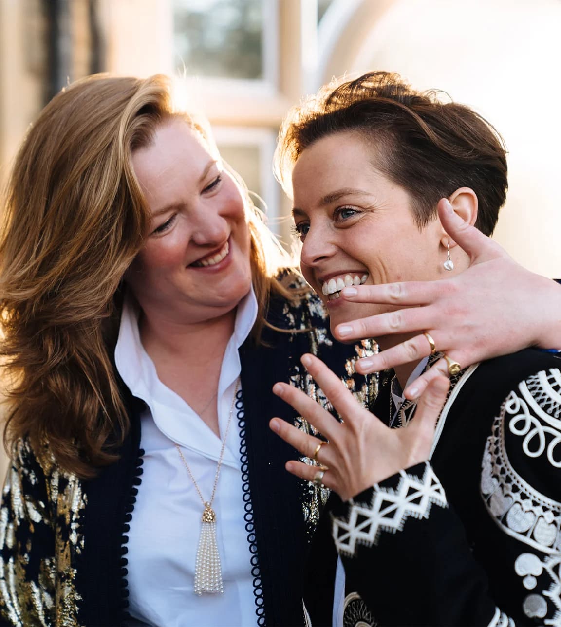 Brides show their rings after their queer wedding and Kingswood house