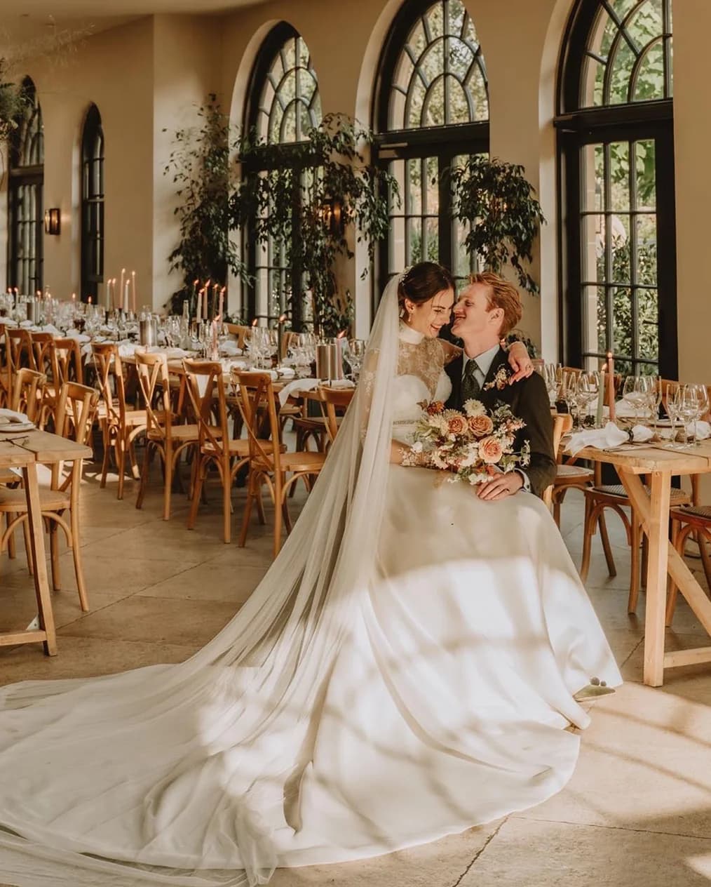 Bride and groom sit in Middleton Lodge dining room with autumnal décor