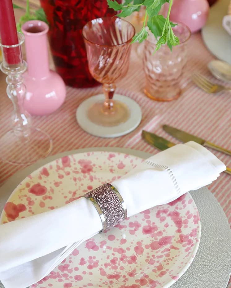 Red-themed Christmas table decor featuring napkin in napkin ring