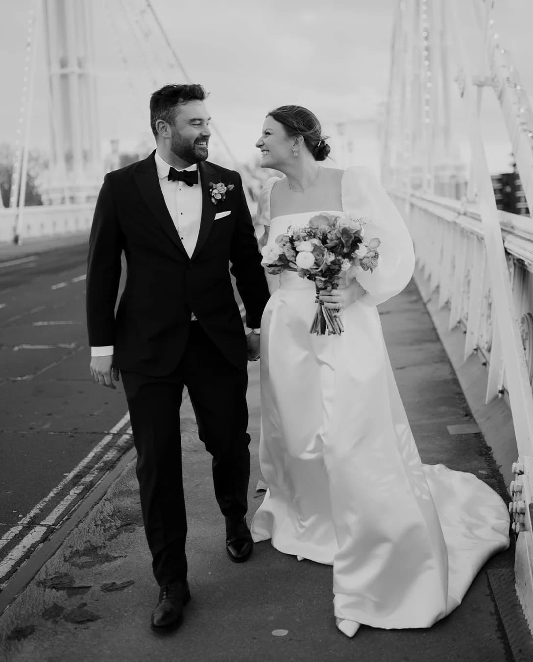 Bride and groom walk across the bridge in London