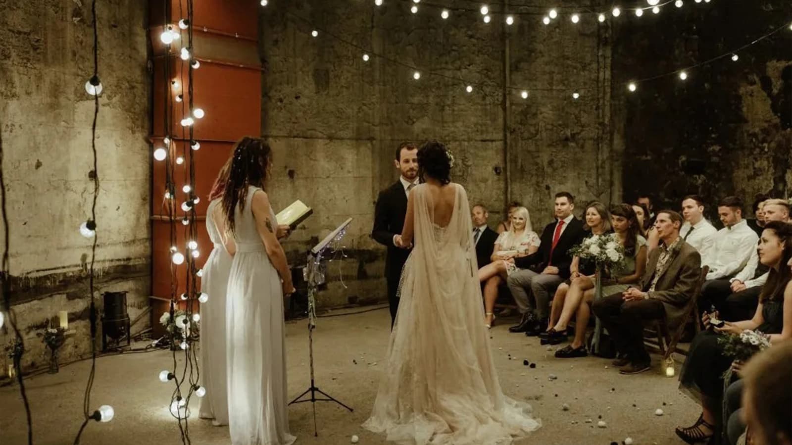 8Wedding ceremony at Brunel Museum London with industrial setting, string lights, and intimate guest seating