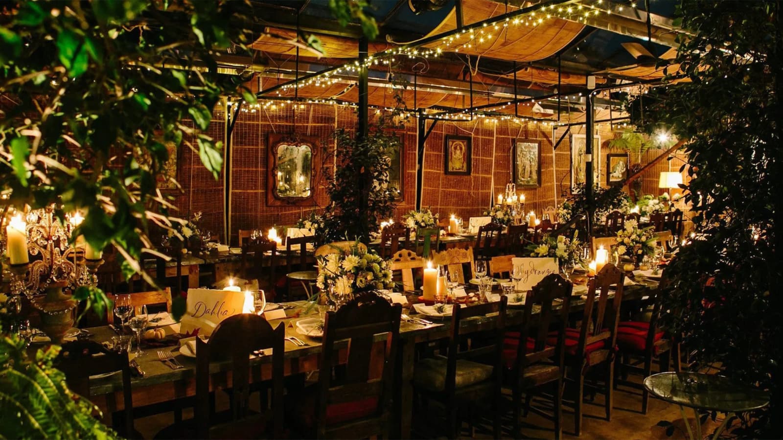 Wedding reception at Petersham Nurseries London with candlelit tables, greenery, and a romantic garden-style setting