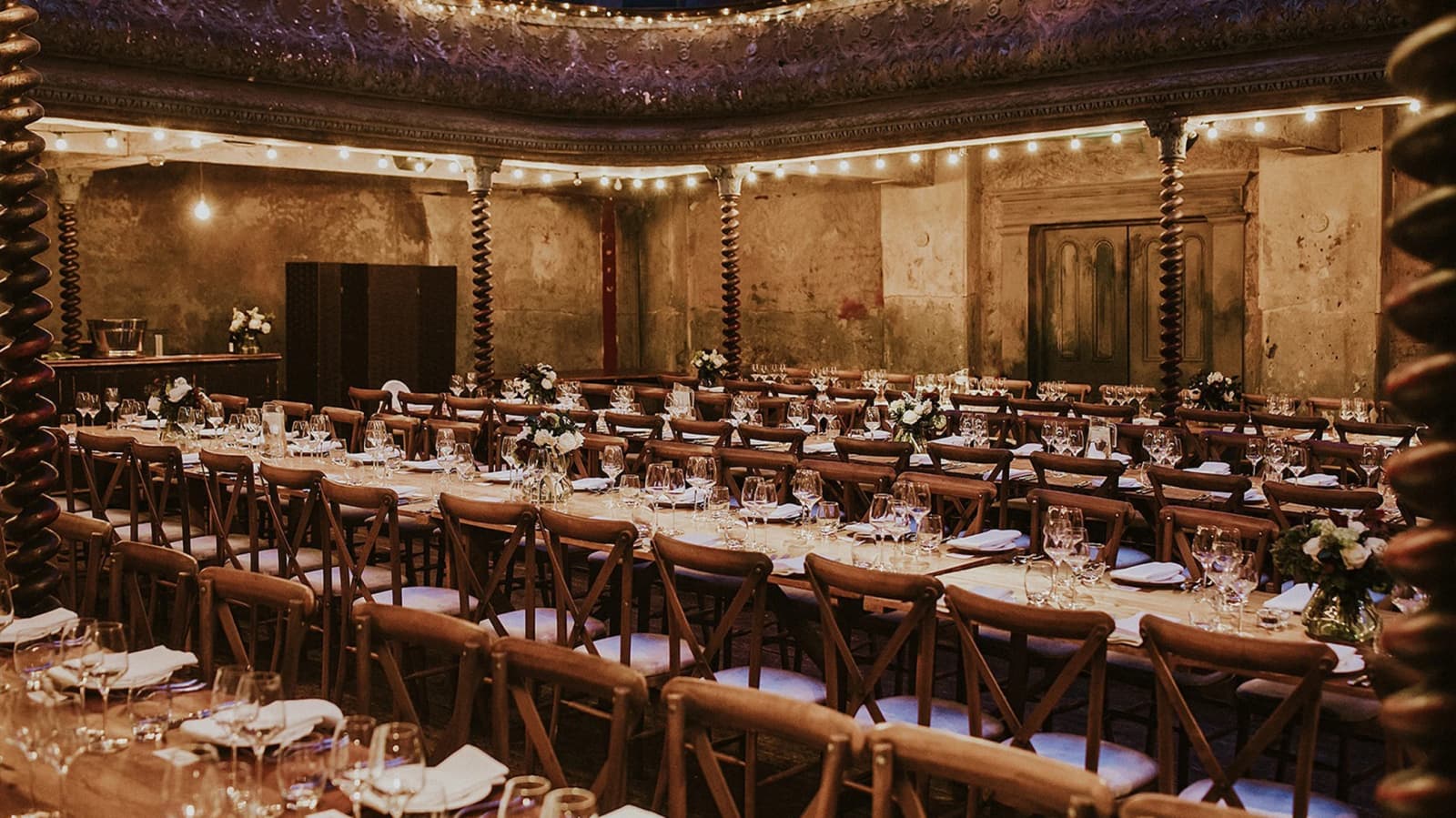Wedding reception at Wilton’s Music Hall London with candlelit tables, rustic décor, and historic interiors