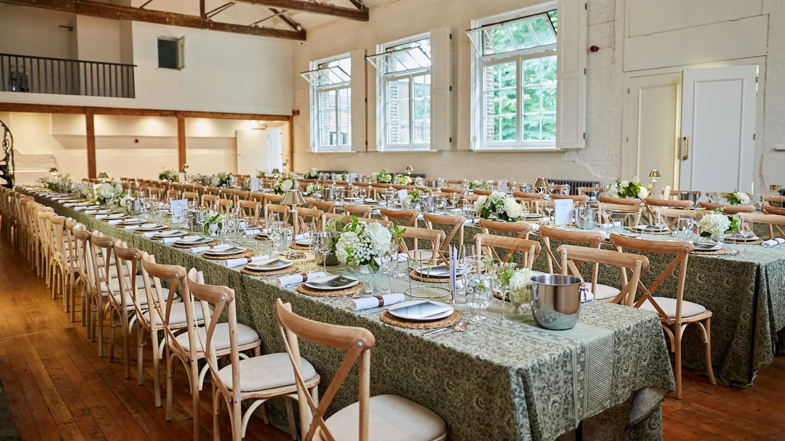 Wedding reception at The Organ Factory London with long banquet tables, greenery décor, and light-filled industrial space