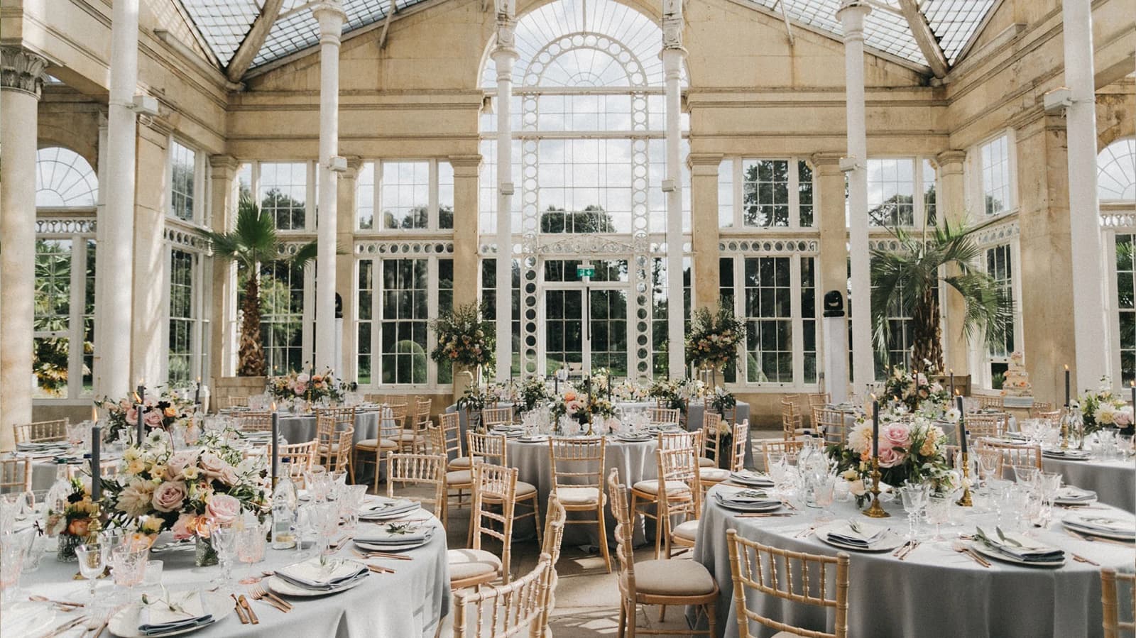 Wedding reception at Syon Park Conservatory London with glasshouse setting, floral tables, and elegant natural light