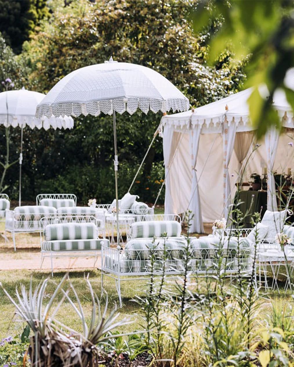 Outdoor wedding lounge at Chelsea Physic Garden London with marquee, parasols, and garden seating
