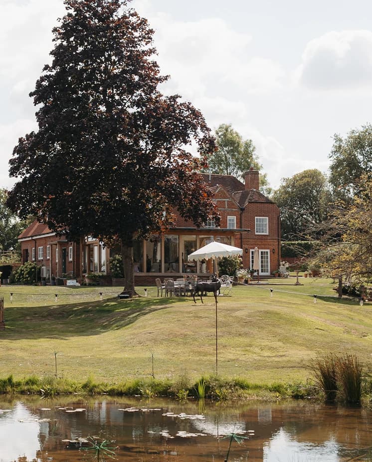 Countryside wedding venue overlooking a tranquil lake, with elegant gardens and outdoor reception spaces