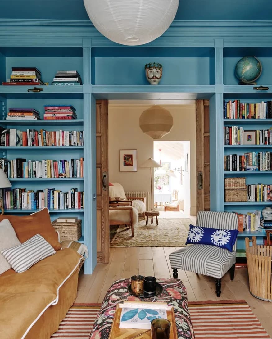 Lucy Williams home, a livingroom with wall bookcase and walls painted in Farrow & Ball Yonder blue