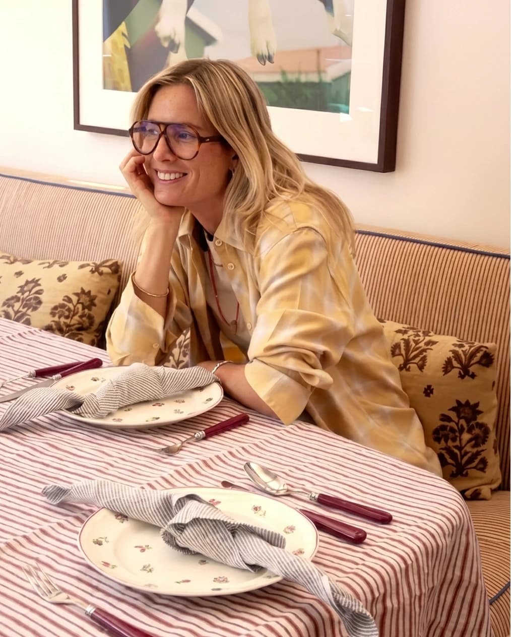 Lucy Williams at home, sitting behind a table set with beautiful wedding gifts from The Wedding Present Company