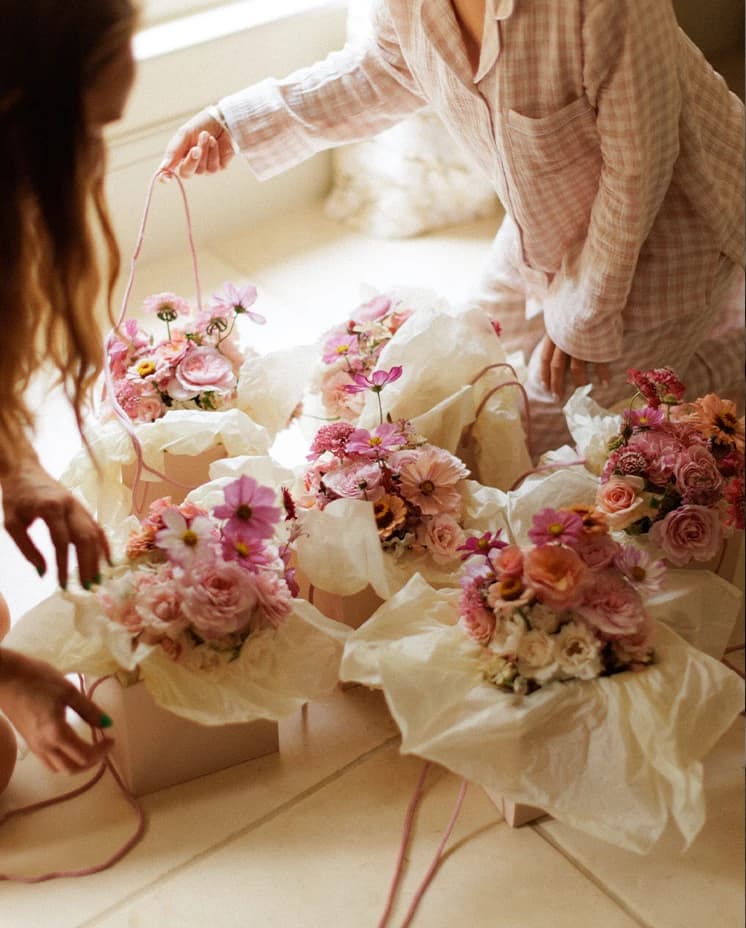 Bridesmaids preparing pink and blush floral bouquets on the wedding morning, capturing elegant bridal details before an English countryside wedding ceremony. 