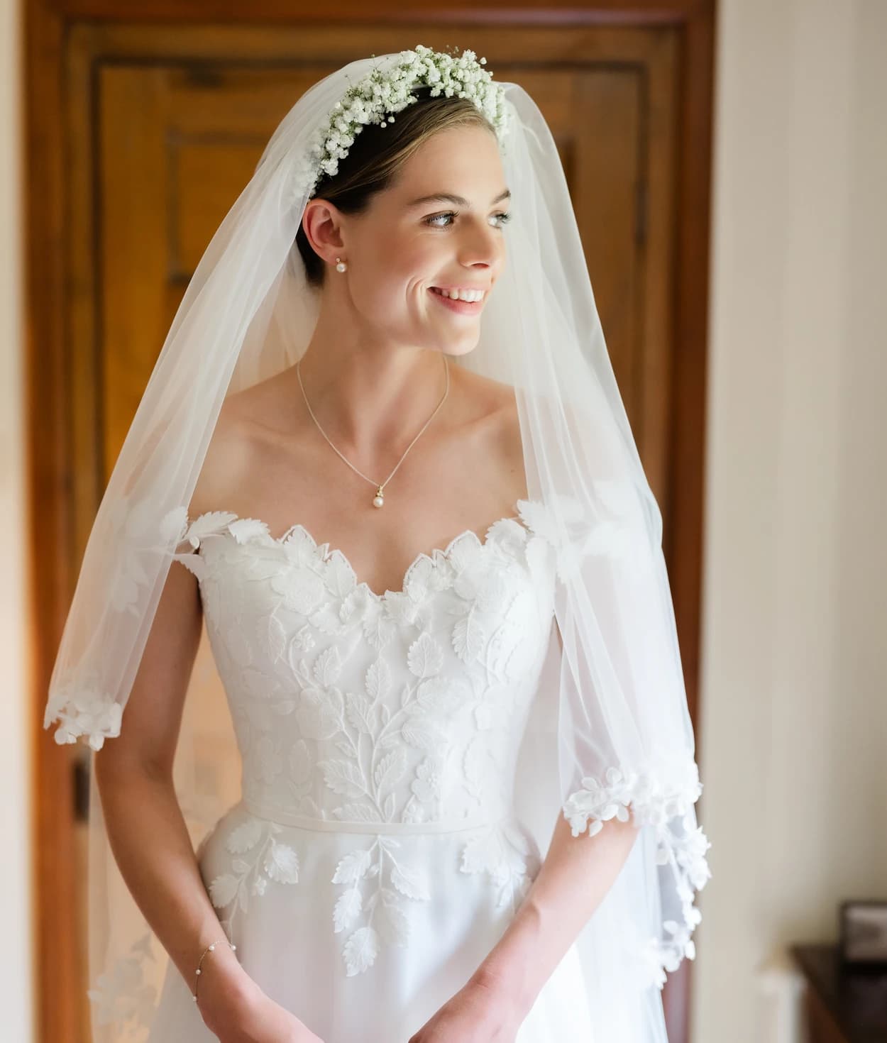 Bride wearing Suzanne Neville dress and veil with 3D flowers
