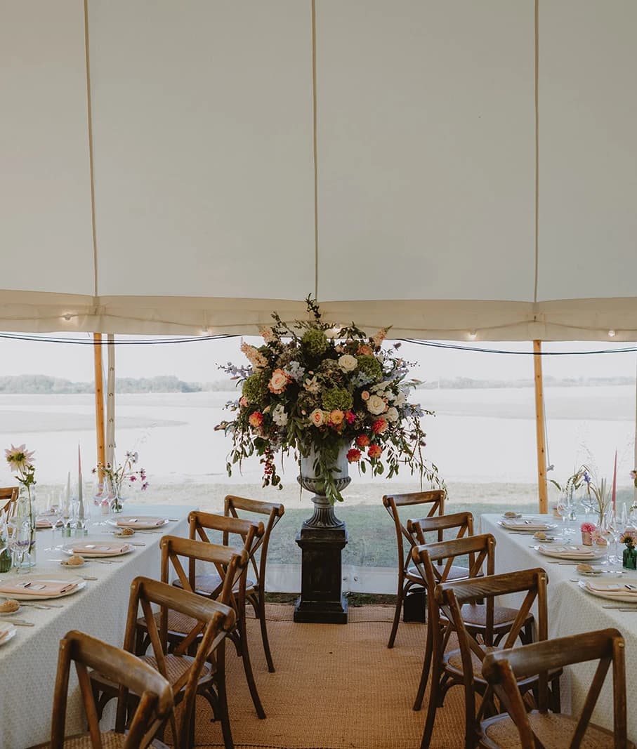 Two long tables leading to a wildflower urn with the Bicester Motion airfield behind