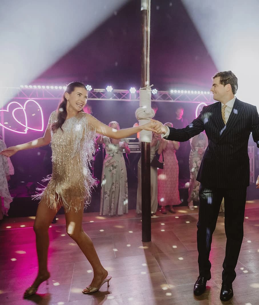Bride and groom disco dancing their first dance as guests watch