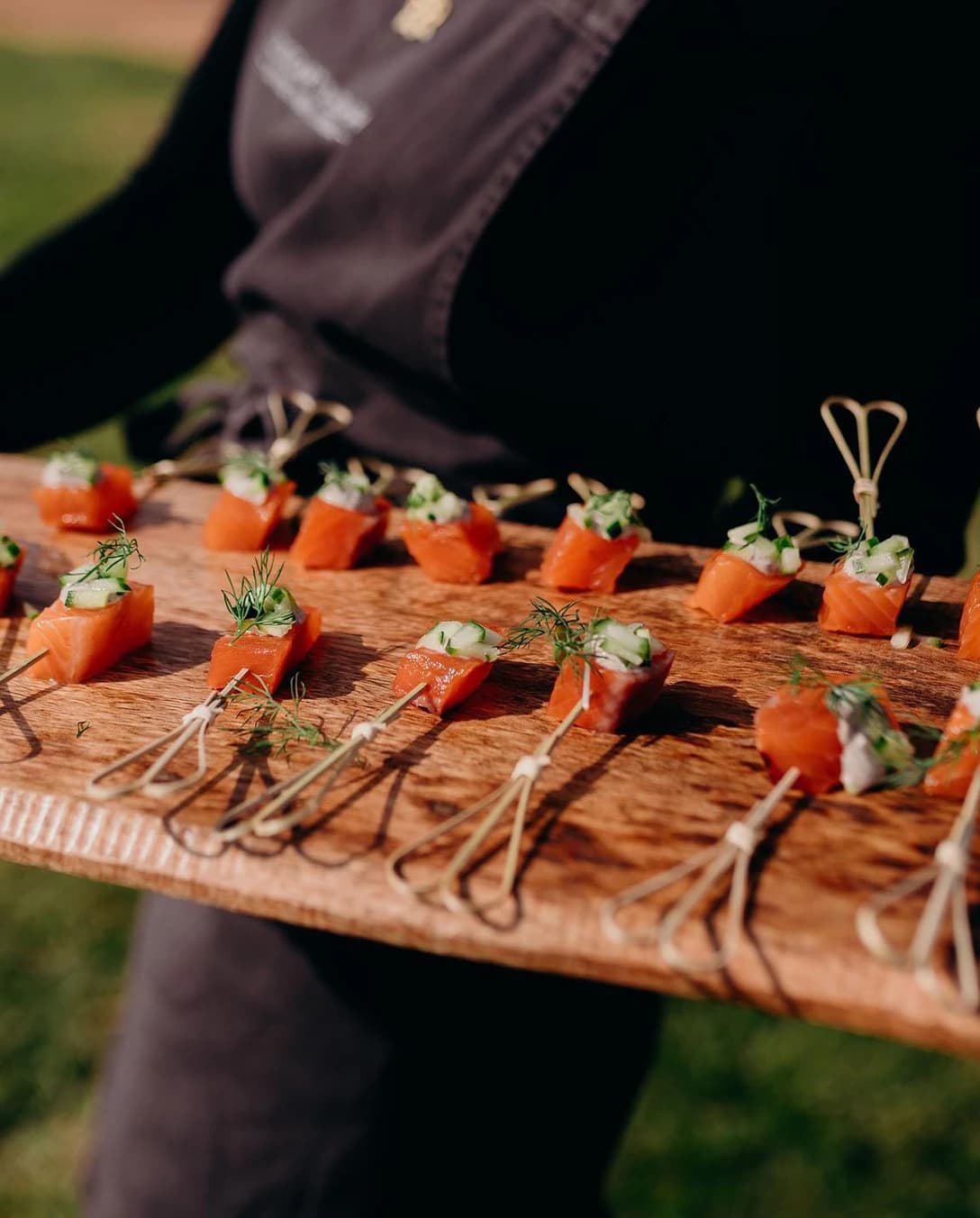 Wedding catering salmon canapes are served on a wooden board